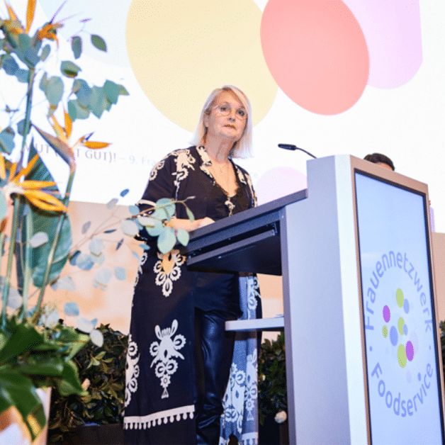 Frauenforum_Ubersicht_Historie Gunilla Hirschberger, Vorstand des Frauenforums, die an einem Podium steht und über die Historie des Forums berichtet.